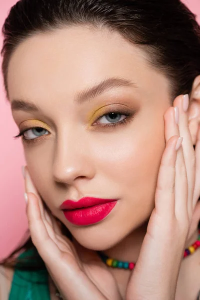 Close up of young model with bright makeup looking at camera isolated on pink — Stock Photo