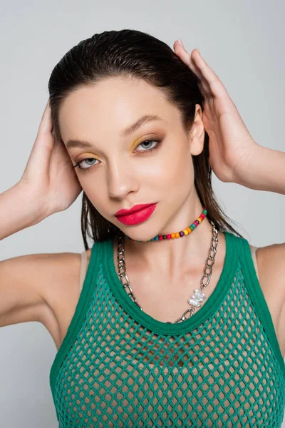 Young brunette woman in trendy outfit with bright makeup isolated on grey — Stock Photo