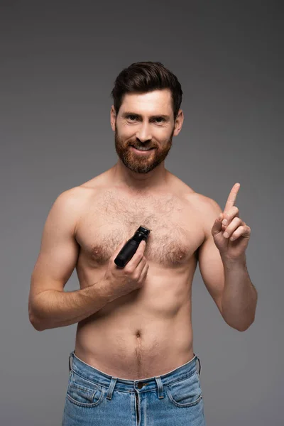 Happy and shirtless man shaving hair on chest with electric razor and gesturing isolated on grey — Fotografia de Stock