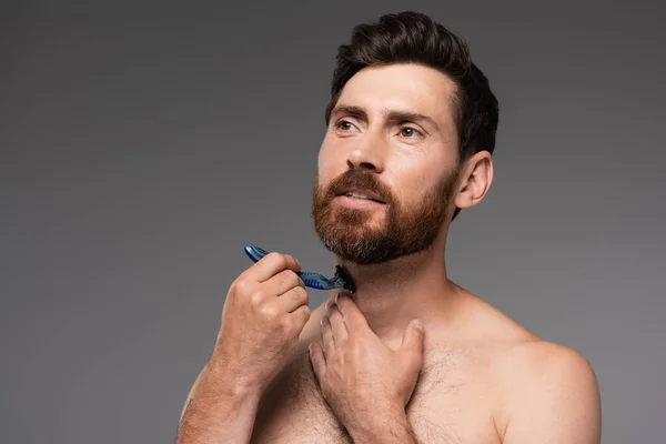 Shirtless man shaving beard with safety razor isolated on grey — Fotografia de Stock