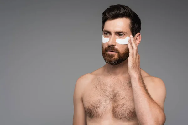 Shirtless and bearded man with moisturizing eye patches isolated on grey — Foto stock