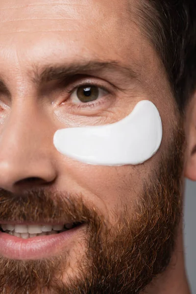 Close up view of happy bearded man with moisturizing eye patch - foto de stock