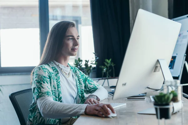 Nonbinary designer using computer in creative agency — Stockfoto