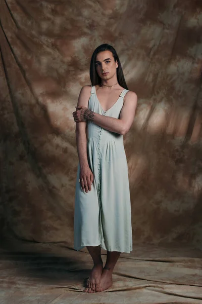 Full length of queer person in dress standing on abstract background — Fotografia de Stock