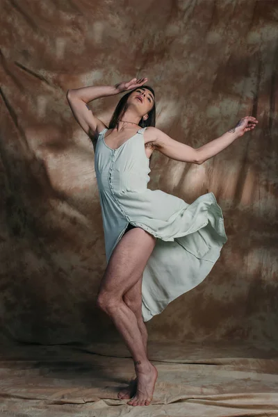 Stylish queer person in sundress posing on abstract brown background — Fotografia de Stock