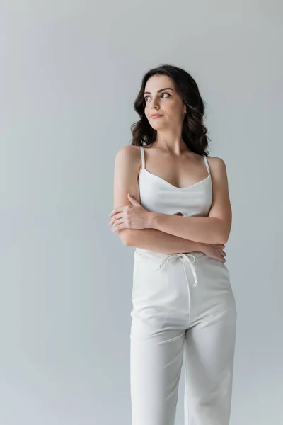 Young woman in white clothes looking away isolated on grey — Foto stock