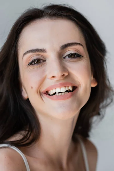 Portrait of cheerful brunette woman looking at camera isolated on grey — Foto stock