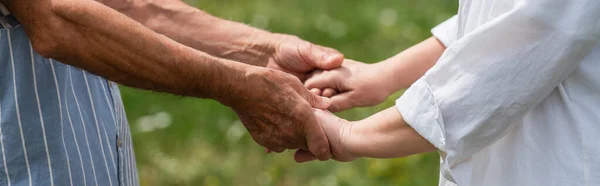 Cropped view of senior husband and wife holding hands in summer, banner — Fotografia de Stock