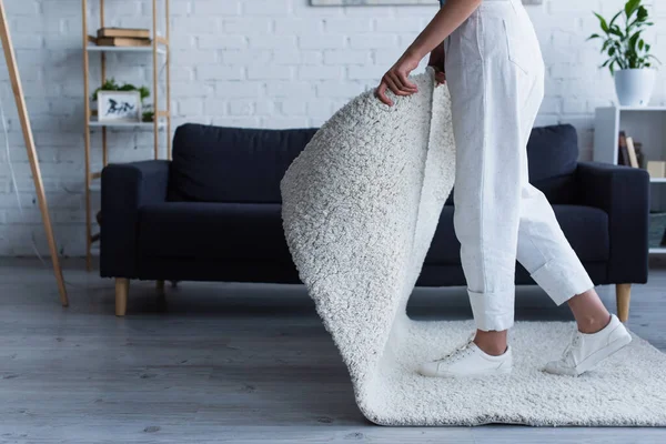 Cropped view of woman taking carpet while cleaning at home — Stock Photo