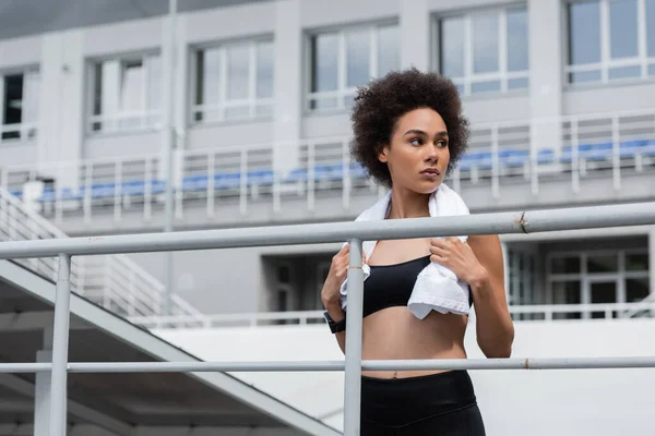 African american sportswoman with white towel looking away on stadium — Stock Photo