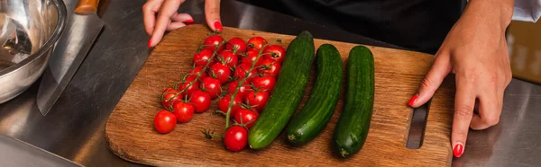 Cropped view of african american woman near ripe vegetables on cutting board, banner — Stock Photo