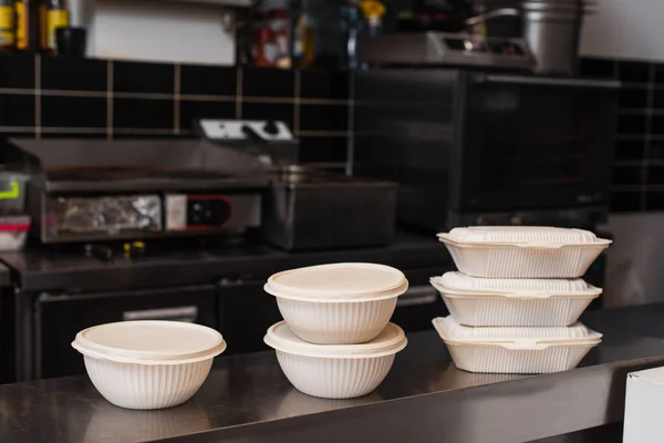 Plastic containers with prepared food for charity in kitchen — Stock Photo