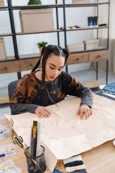 African american designer looking at sewing pattern in workshop — Foto stock