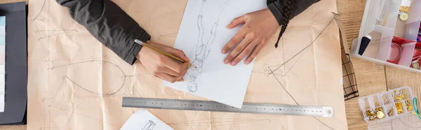 Top view of african american designer drawing sketch on sewing print in workshop, banner — Stock Photo