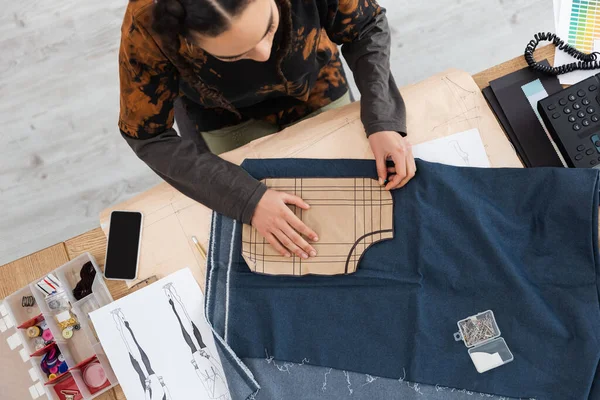 Overhead view of african american craftswoman purring sewing print on cloth in workshop — Stock Photo