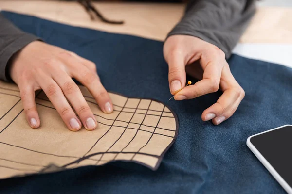 Cropped view of african american designer holding needle near sewing print and cloth - foto de stock