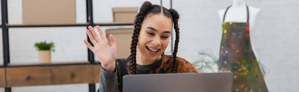 Cheerful african american craftswoman having video call on laptop in workshop, banner — Foto stock
