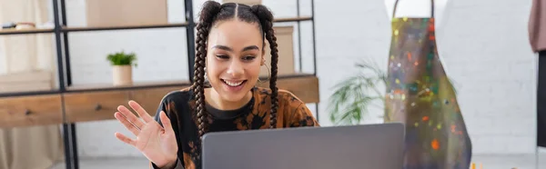 Cheerful african american craftswoman having video call on laptop in workshop, banner — Stock Photo