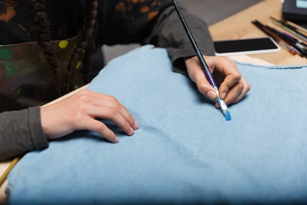 Cropped view of african american designer painting on cloth — Photo de stock