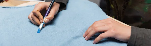 Cropped view of african american craftswoman painting on cloth, banner — Stock Photo