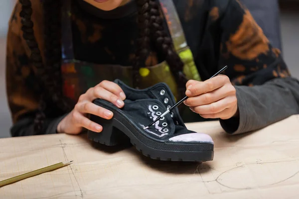 Cropped view of african american craftswoman painting on shoe on sewing pattern in workshop — Stock Photo