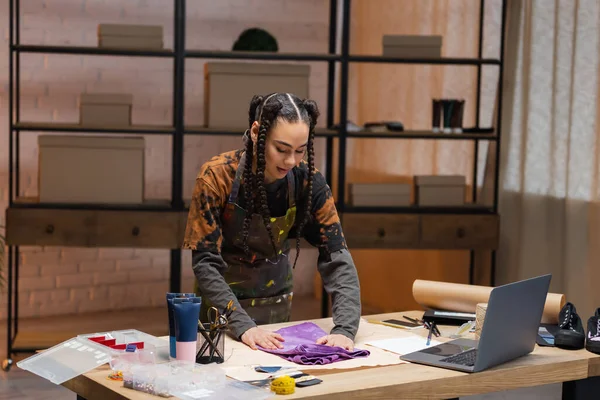 African american craftswoman putting cloth on sewing pattern in workshop — Foto stock