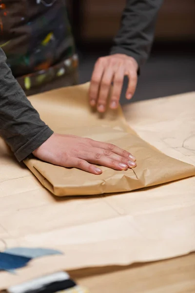 Cropped view of african american designer packaging paper in workshop - foto de stock