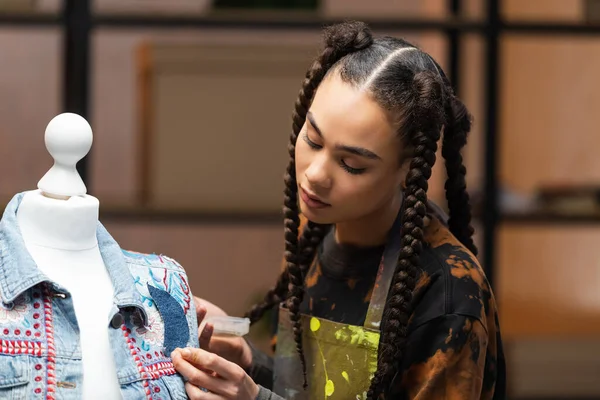 African american craftswoman decorating denim jacket on mannequin — Photo de stock