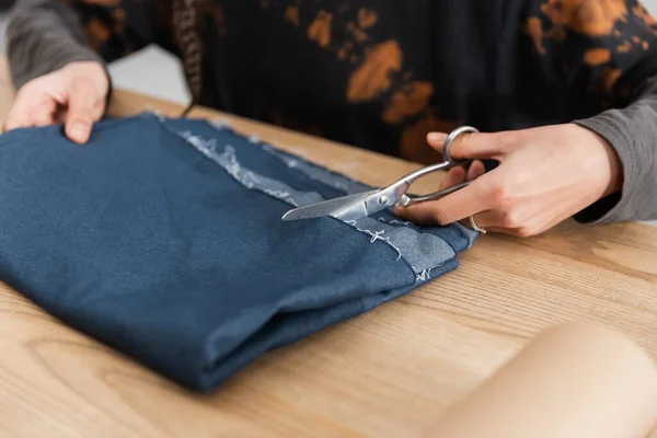 Cropped view of african american designer cutting fabric in workshop — Photo de stock