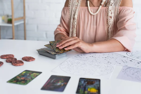 KYIV, UKRAINE - JUNE 29, 2022: partial view of fortune teller near tarot cards and constellation maps — Stock Photo