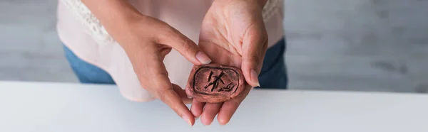 Cropped view of clay rune in hands of cropped fortune teller, banner — Stock Photo