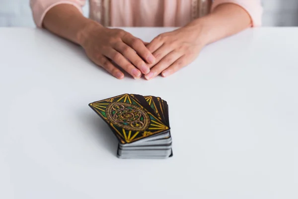 KYIV, UKRAINE - JUNE 29, 2022: selective focus of tarot cards near cropped fortune teller on blurred background — Stock Photo