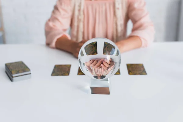 KYIV, UKRAINE - JUNE 29, 2022: cropped view of blurred fortune teller near crystal ball and tarot cards — Fotografia de Stock