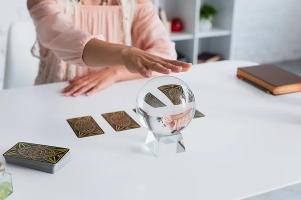 KYIV, UKRAINE - JUNE 29, 2022: partial view of predictor executing spiritual session with crystal ball and tarot cards — Foto stock