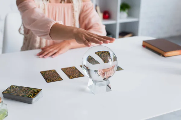 KYIV, UKRAINE - JUNE 29, 2022: partial view of predictor executing spiritual session with crystal ball and tarot cards — Fotografia de Stock