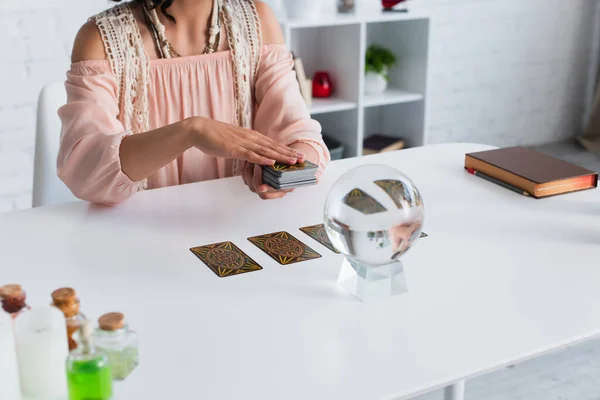 KYIV, UKRAINE - JUNE 29, 2022: cropped view of fortune teller near crystal ball and tarot cards — Fotografia de Stock