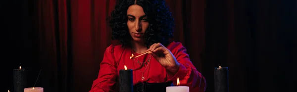 Brunette medium lighting palo santo stick during spiritual session on dark background, banner — Photo de stock