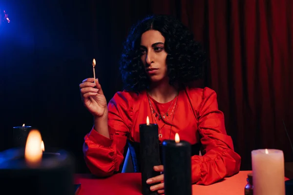 Brunette medium with burning palo santo stick on dark background — Photo de stock