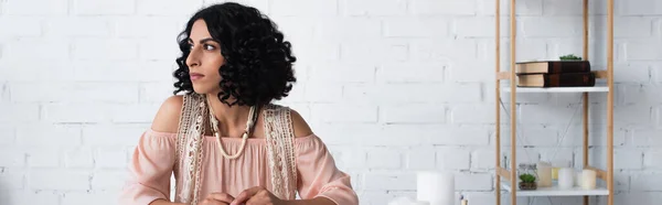 Brunette fortune teller looking away near candles at home, banner — Foto stock