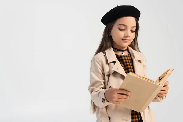 Cute girl in stylish autumnal outfit and beret reading book isolated on grey — Foto stock