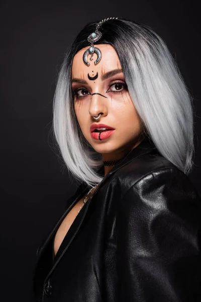Frau in Hexenhalloween-Make-up und Piercing schaut isoliert auf schwarz in die Kamera — Stockfoto