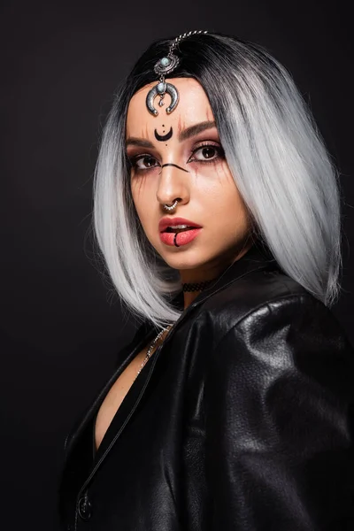 Woman in witch halloween makeup and piercing looking at camera isolated on black — Stock Photo