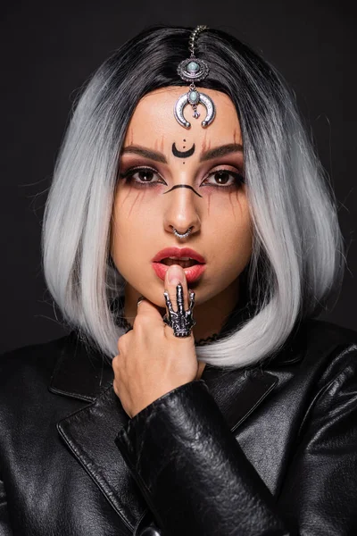 Retrato de mujer joven en maquillaje de bruja y accesorios aislados en negro - foto de stock