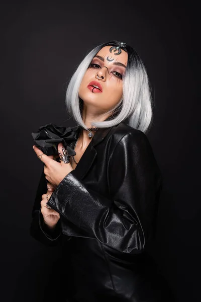 Sexy witch style woman with ash blonde hair and dark rose looking at camera isolated on black — Stock Photo