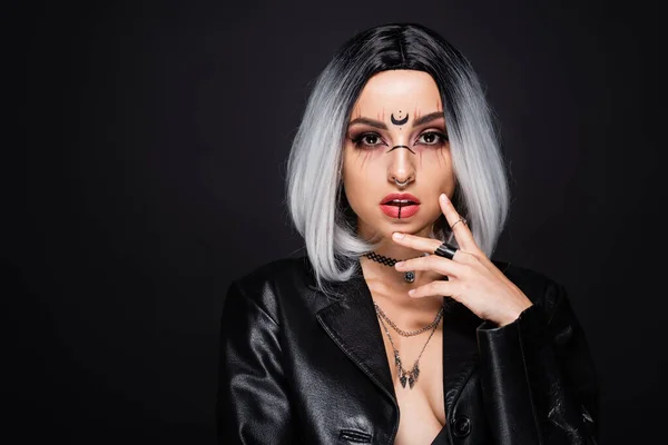Sexy ash blonde woman with halloween makeup touching face and looking at camera isolated on black — Stock Photo