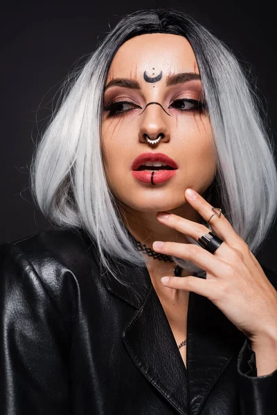Retrato de mujer sexy con el maquillaje de Halloween y ceniza pelo rubio sosteniendo la mano cerca de la cara aislada en negro - foto de stock