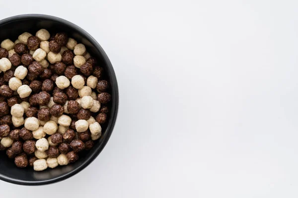 Top view of cereal balls with chocolate and vanilla flavors in bowl isolated on white — Stock Photo