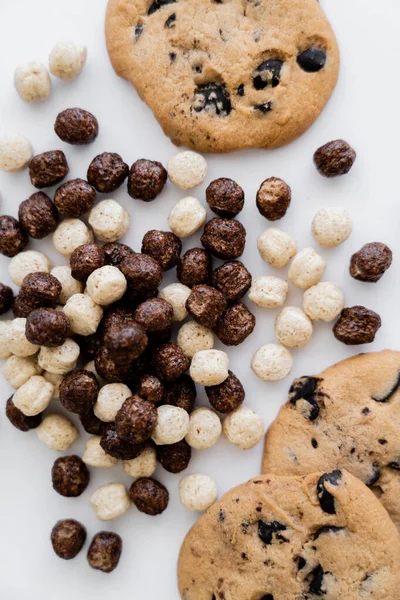 Vista superior de biscoitos saborosos perto de bolas de cereais isoladas em branco — Fotografia de Stock