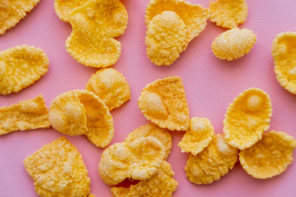 Top view of tasty and yellow corn flakes on pink background — Stock Photo