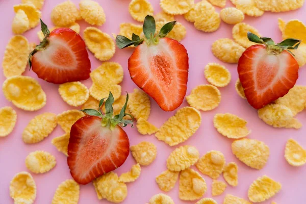 Nahaufnahme von frischen Erdbeeren in Scheiben um knusprige Cornflakes auf rosa — Stockfoto